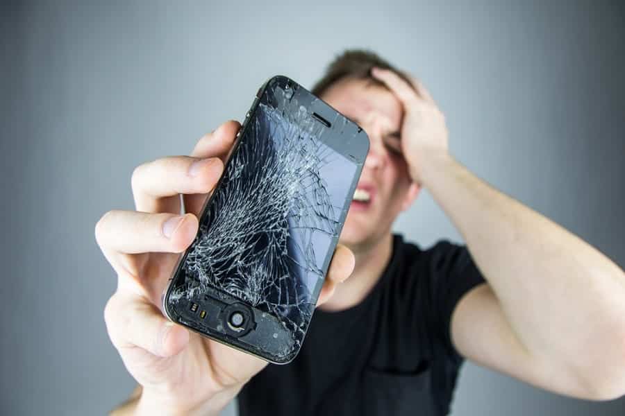 close up of a guy holding his broken phone