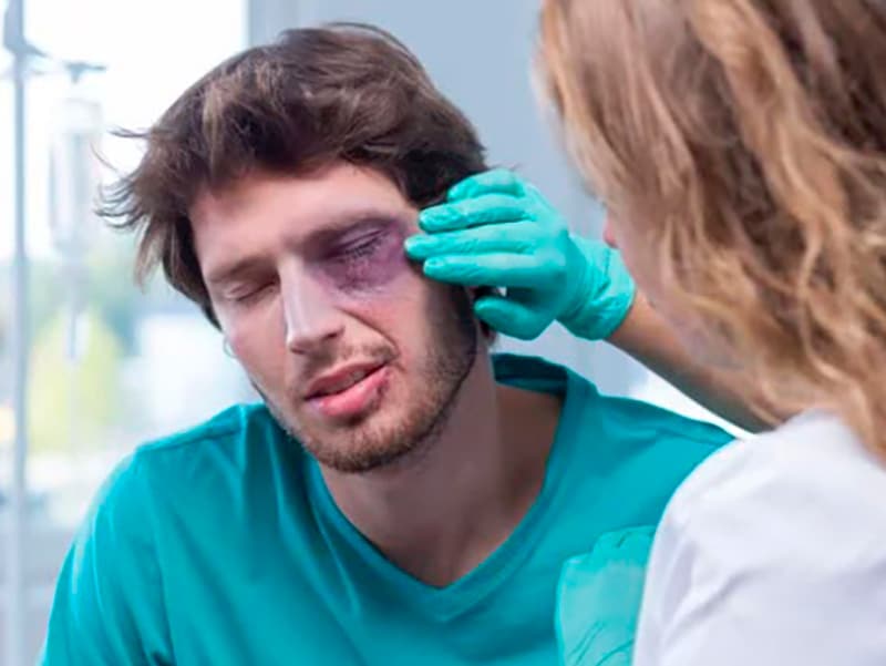 a doctor looking at a man with a black eye