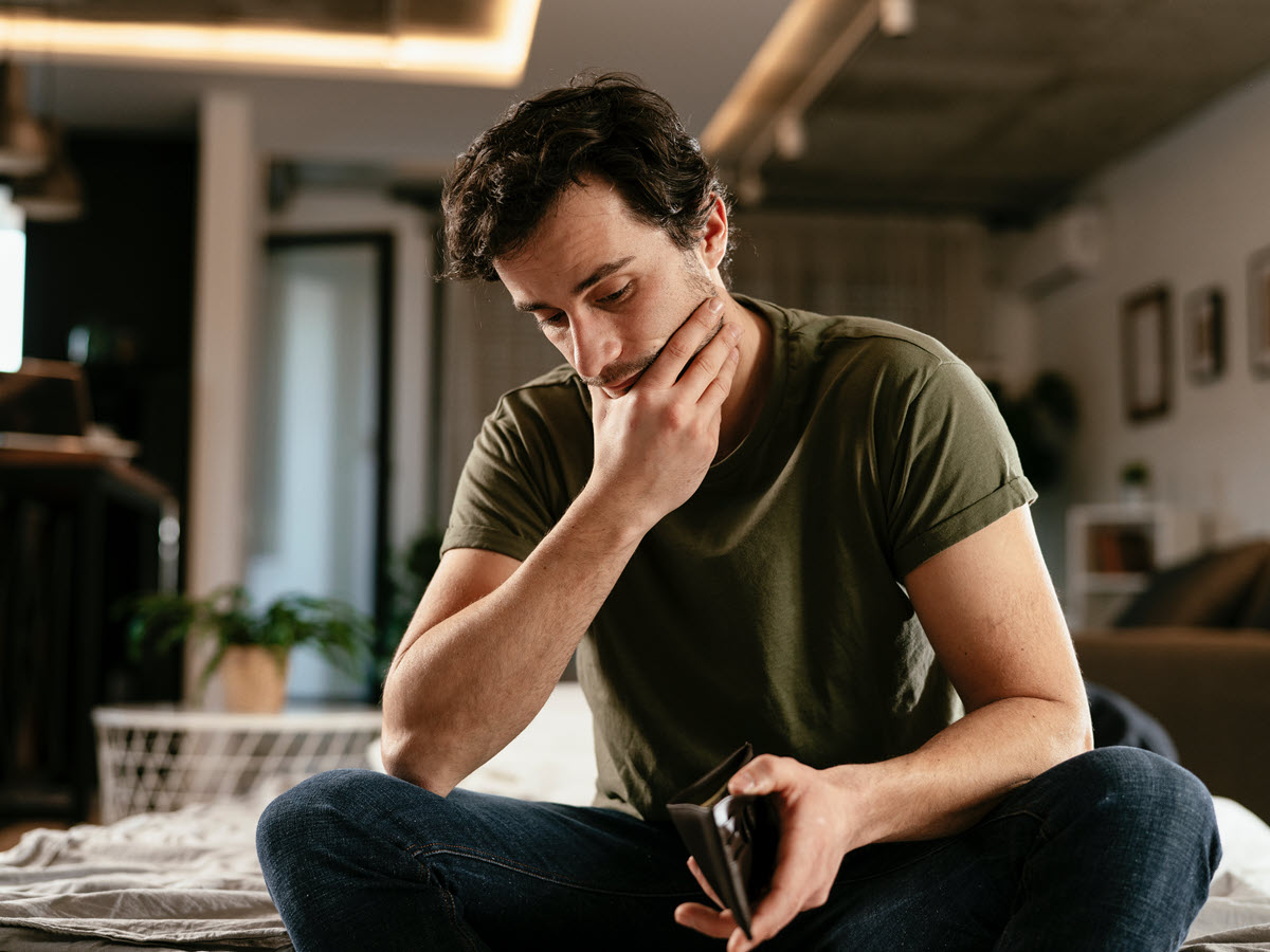 Man staring at his empty wallet