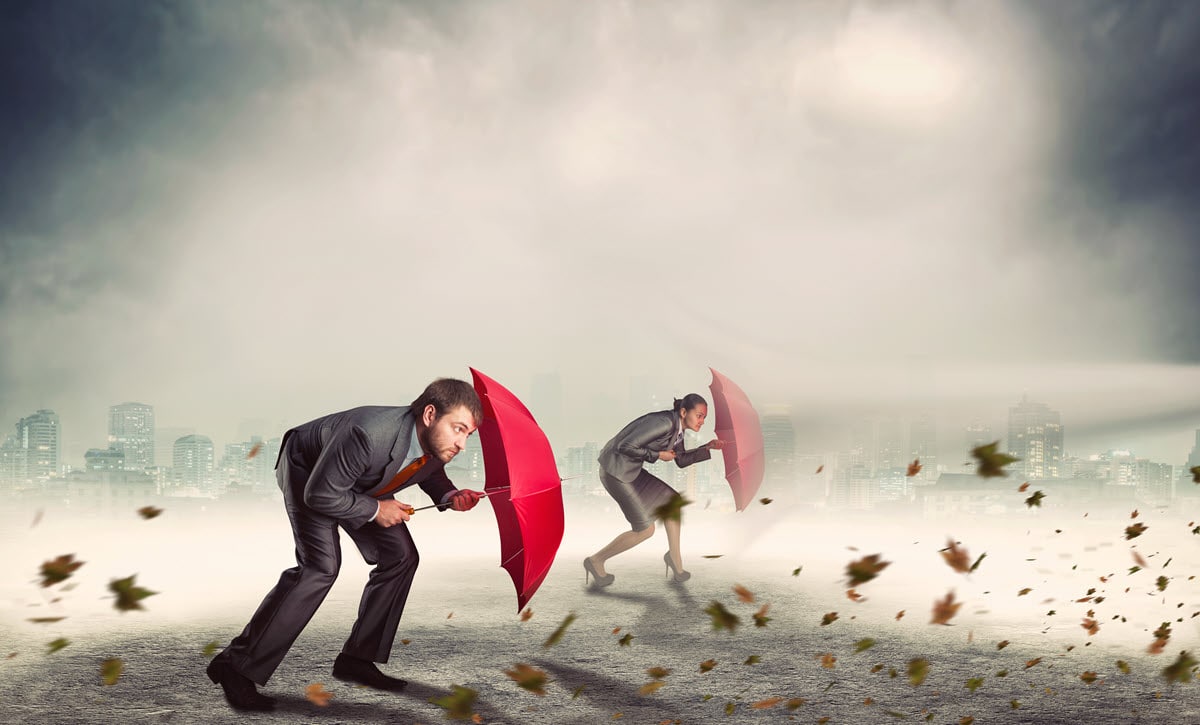 two people holding umbrellas fighting off a bad storm