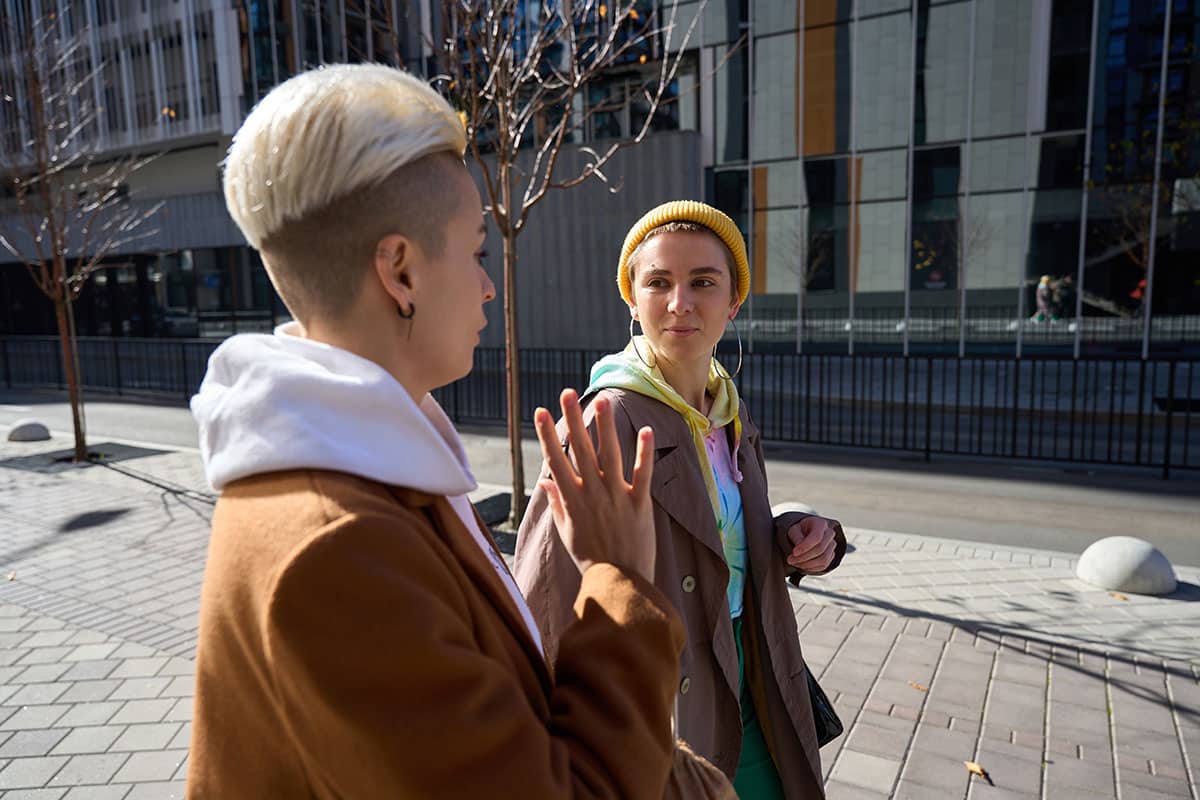 two women with trendy short haircuts walking outside