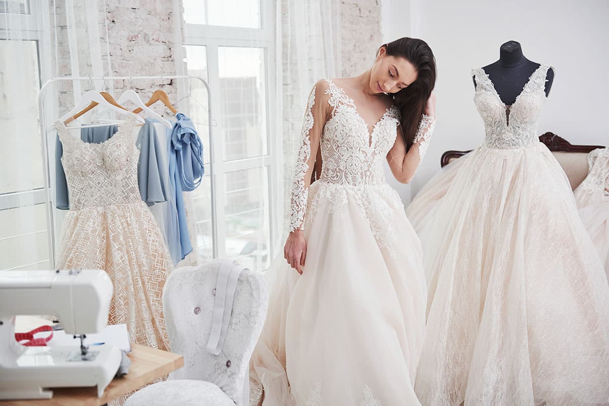 bride looks dismayed with her wedding dress because she now needs an excuse for being late to a wedding because she had a wardrobe malfunction