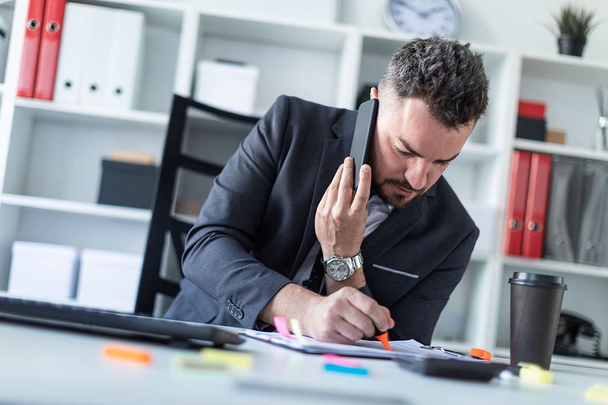 man in an office on the phone getting clarification on a pertinent issue