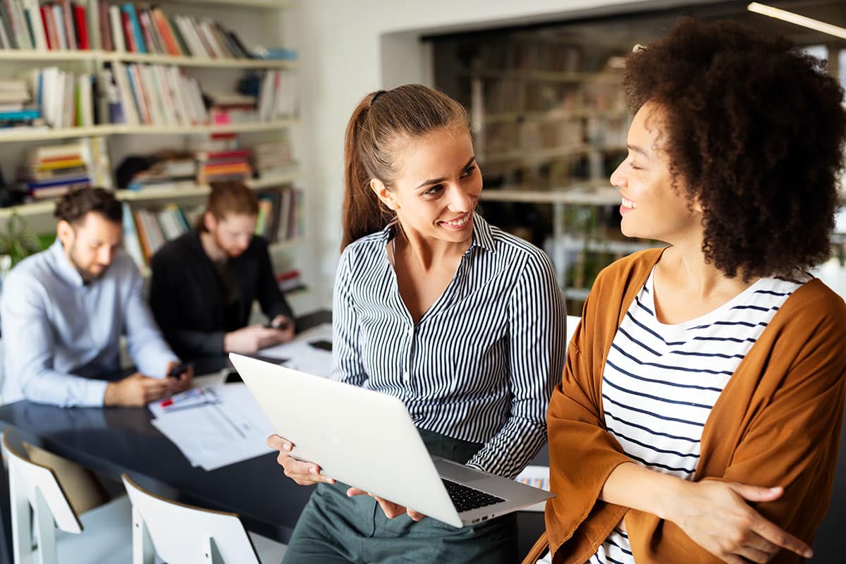 woman talking to her colleague making an excuse to question authority by opening a discussion with her boss