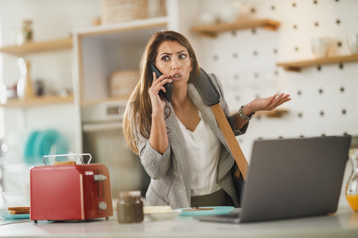 frantic woman on the phone in front of her laptop is super busy and needs excuses to ask for advice