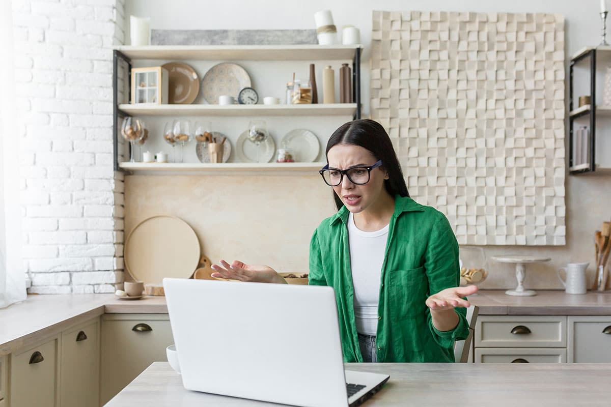 woman in green shirt throws her hands up because her internet connection means she needs an excuse for asking for advice