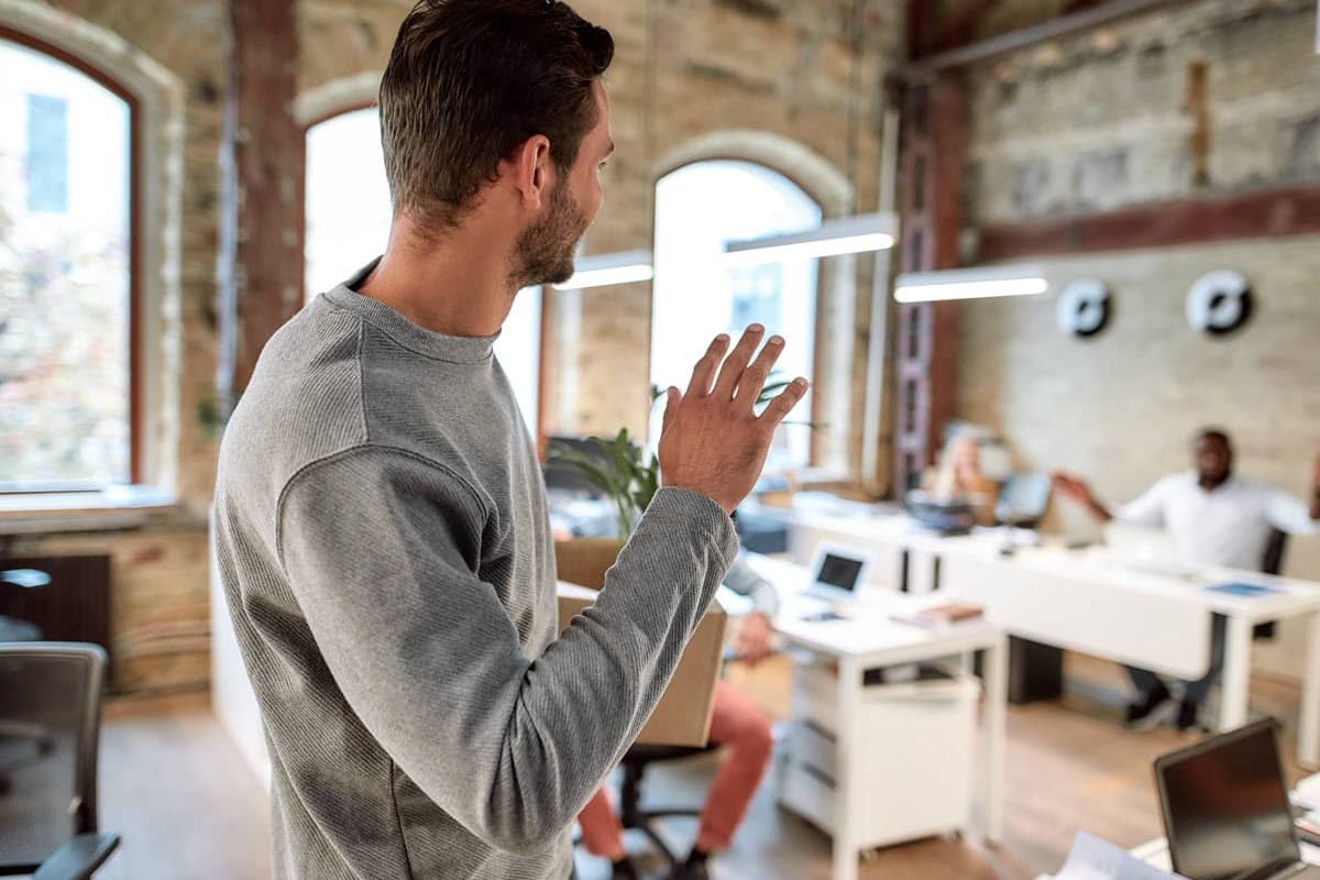 man waving goodbye as he leaves work early