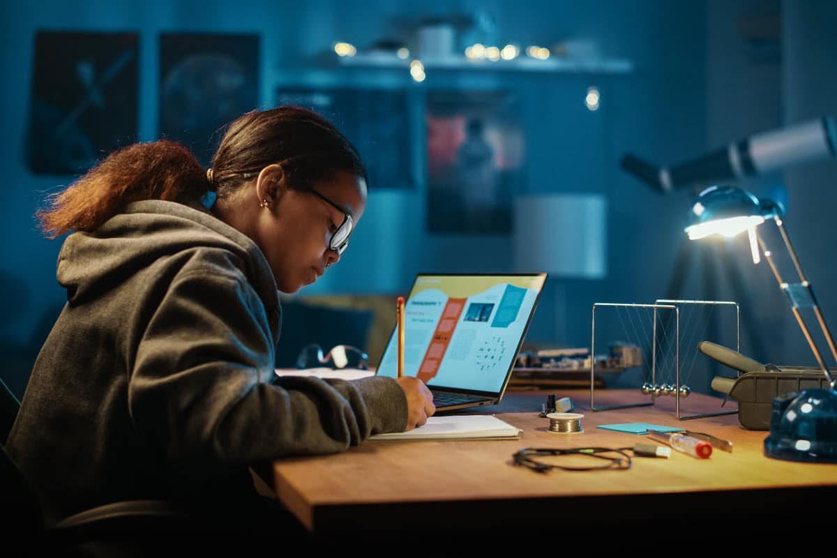 girl doing homework at her desk in her room